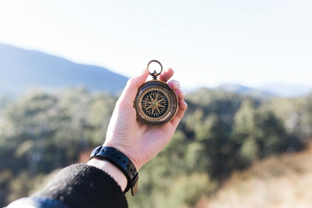 A person looking at a compass to find his way out 