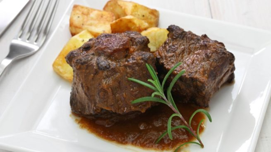 bull's tail (rabo de toro) accompanied with potatoes on a plate, one of the most delicious spanish food